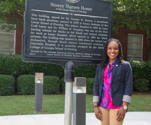 woman stands in front of history Stoney Nurses Home sign