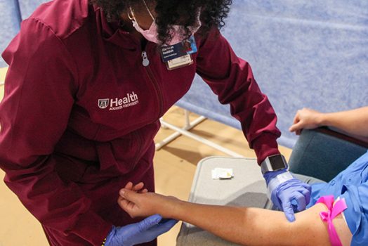 A nurse preparing to draw blood.