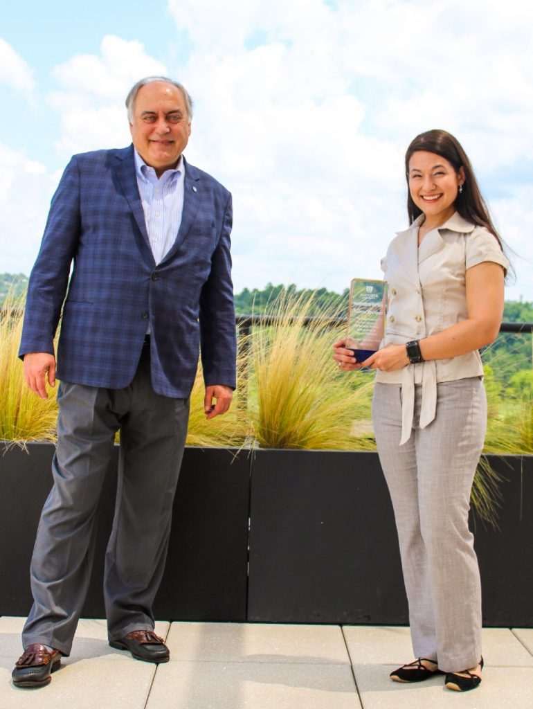 Dr. Alex Schwarzmann and Julianna Rodriguez pose with Julianna's Volunteer of the Year award at the Georgia Cyber Center.