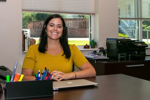 Woman in gold shirt at desk