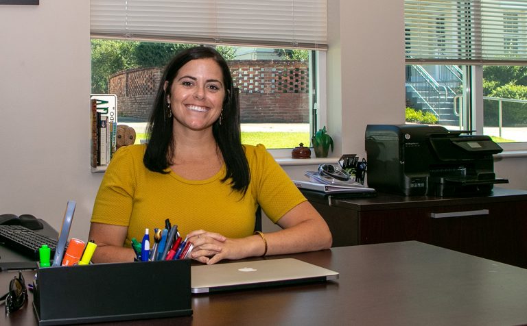 Woman in gold shirt at desk