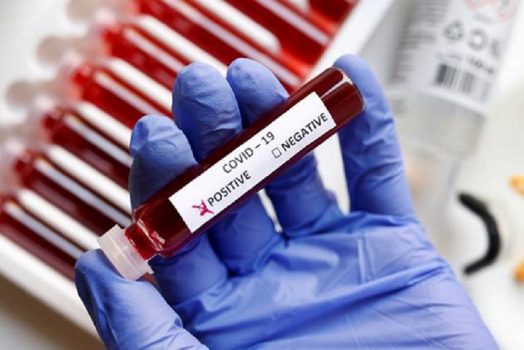 glove hand holding blood vial