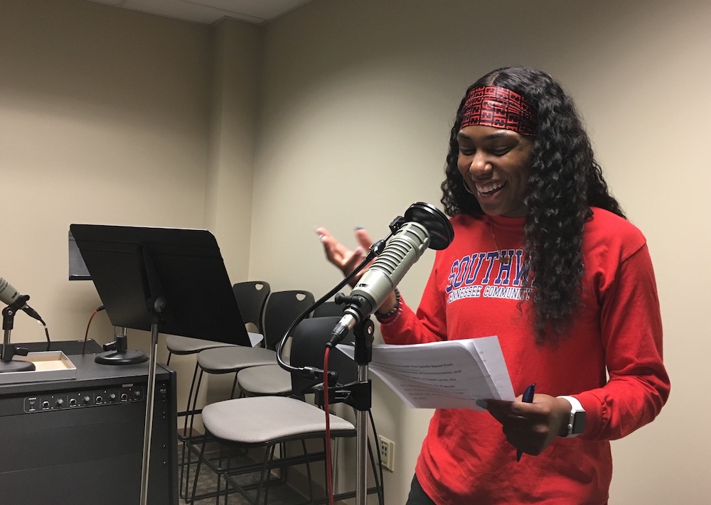 Woman speaking into a microphone.