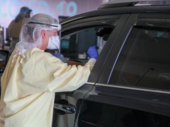 nurse performs test by car