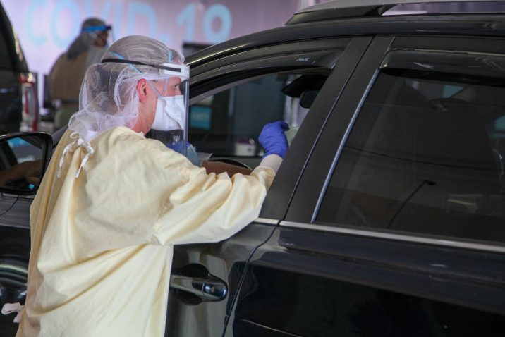 nurse performs test by car