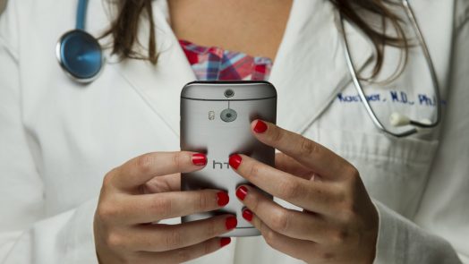 A doctor holding a phone in her hands.