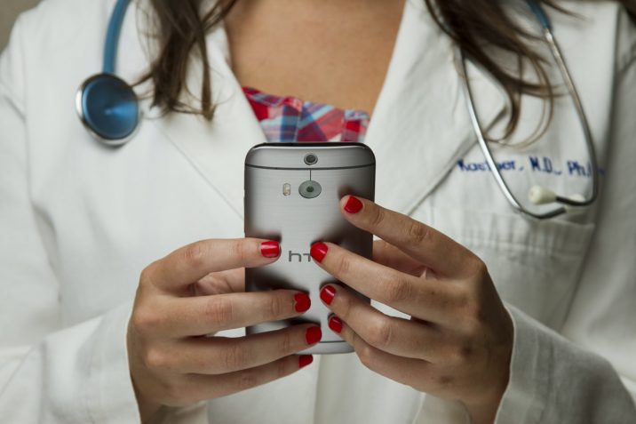 A doctor holding a phone in her hands.