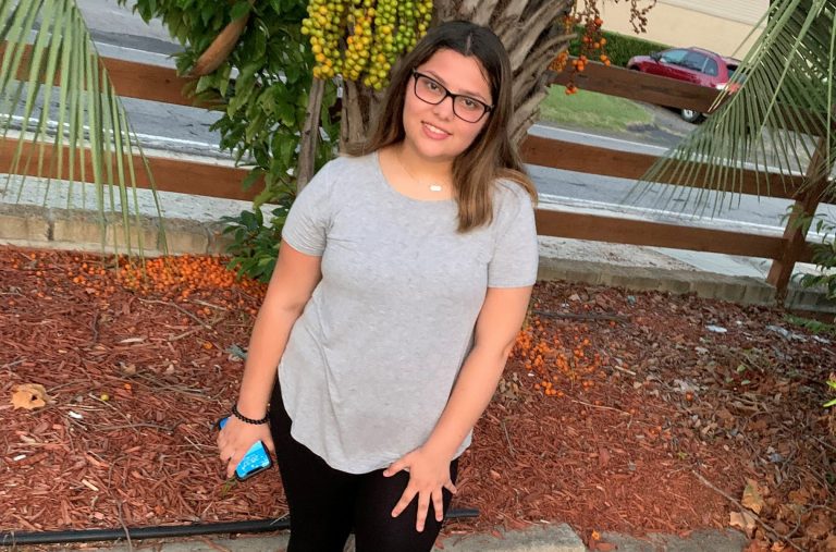 Teenage girl in a grey shirt and black pants.
