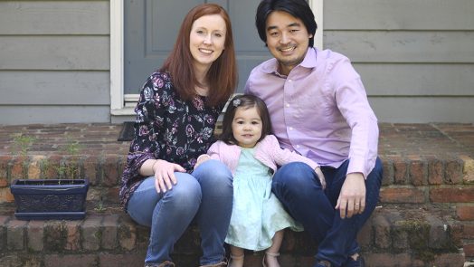 Wife, daughter and husband sit on steps