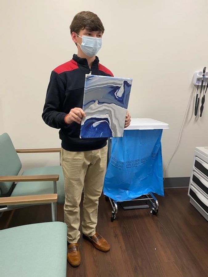 Teen boy holding painting