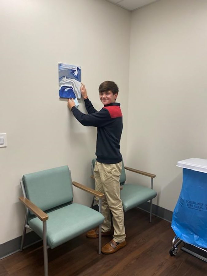 Teen boy hanging painting