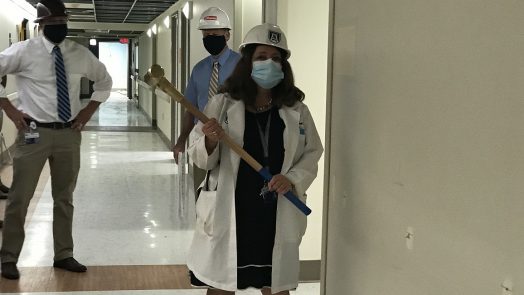 female physician holds sledgehammer