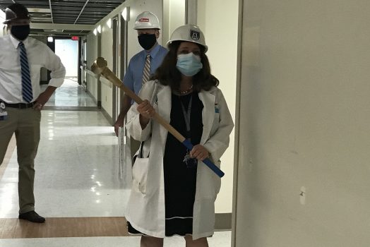 female physician holds sledgehammer