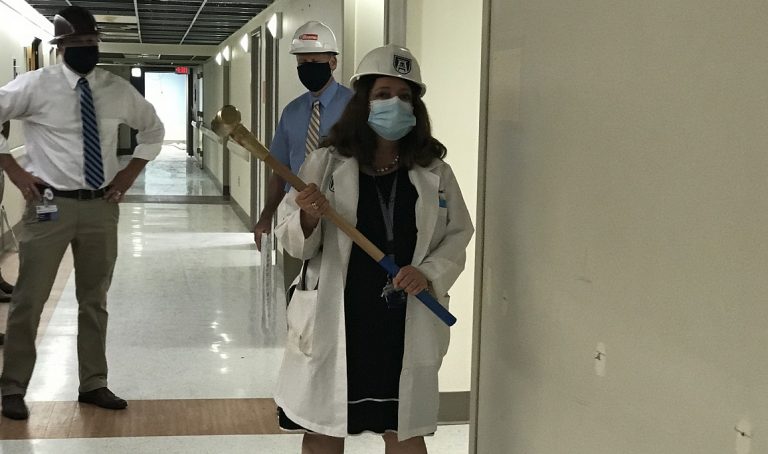 female physician holds sledgehammer