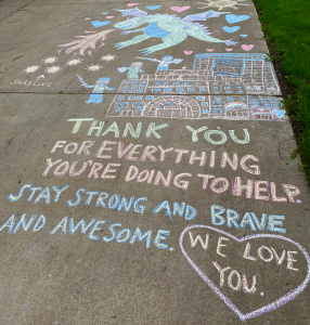 Chalk art of a dragon over a hospital. Caption: "THANK YOU FOR EVERYTHING YOU'RE DOING TO HELP. STAY STRONG AND BRAVE AND AWESOME. WE LOVE YOU."