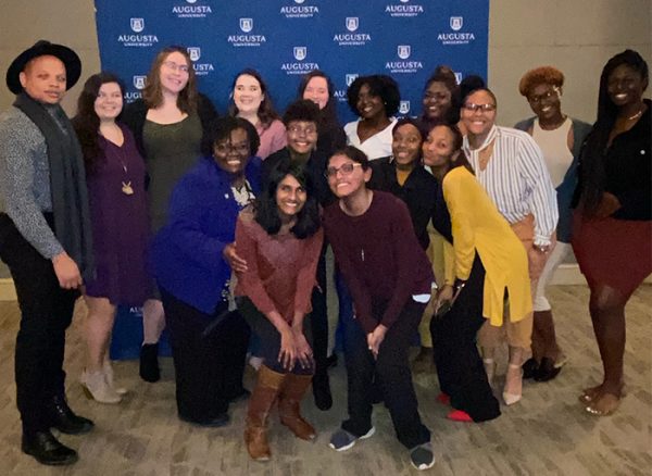 group of students in front of Augusta University banner