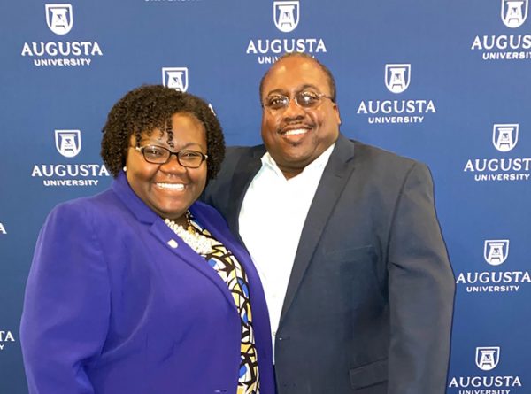 woman and man in front of Augusta University background