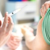 hand holds needle for vaccine