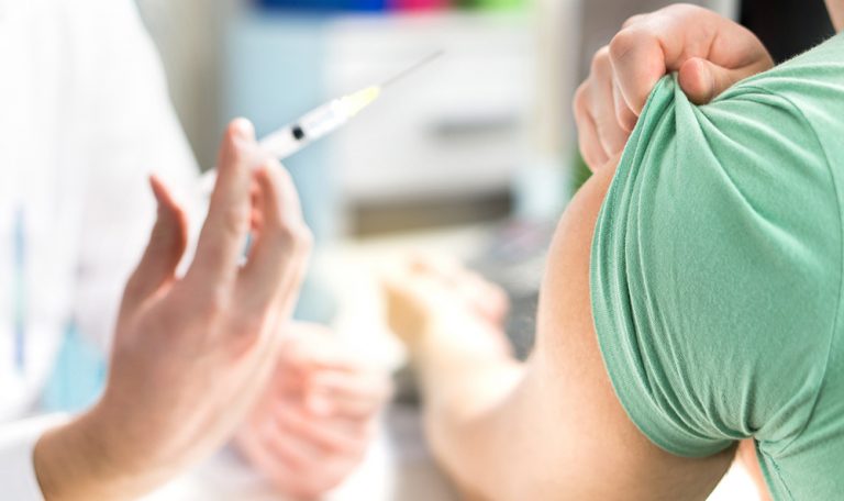 hand holds needle for vaccine