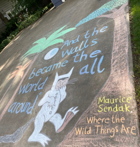 Chalk drawing of trees and the character Max from Where the Wild Things Are. Caption: "And the walls became the world all around. - Maurice Sendak, Where the Wild Things Are"