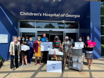 people in front of hospital entrance with signs and carts of food