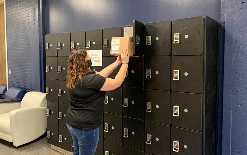 woman puts box in locker