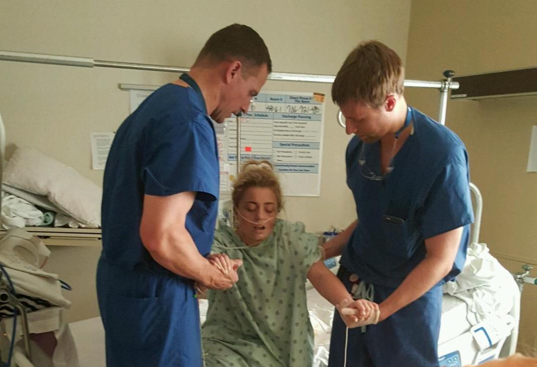 woman helped up by two doctors