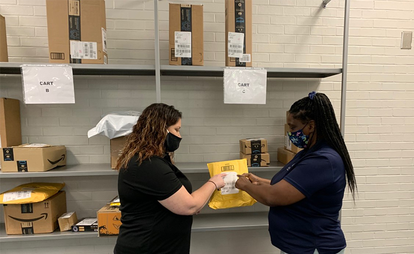 two women hold a large envelope