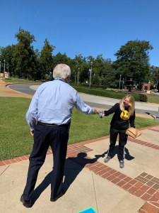 President Keel hands a T-shirt to a female student on the Summerville Campus