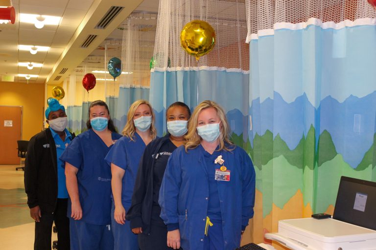 women lined up by curtains