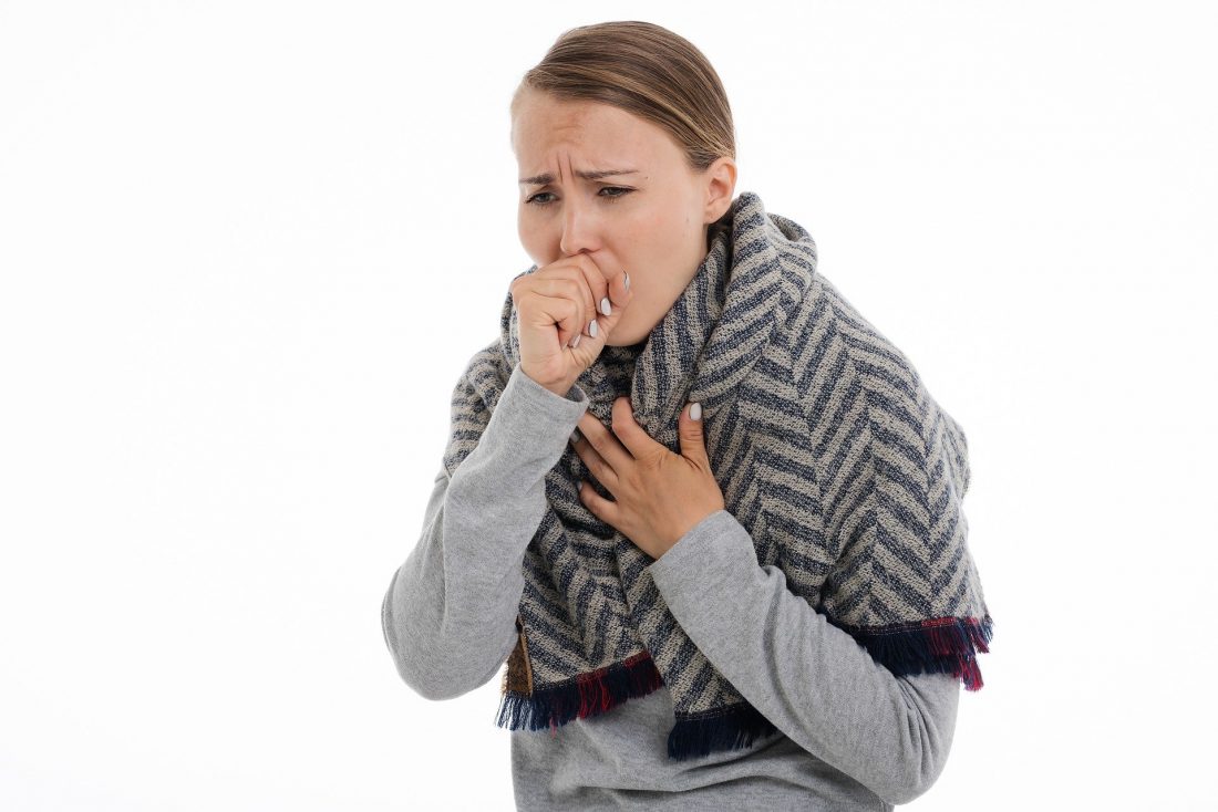 Woman coughing into her hand.