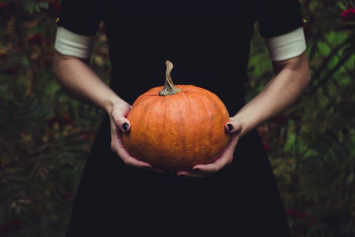 A woman holding a pumpkin.