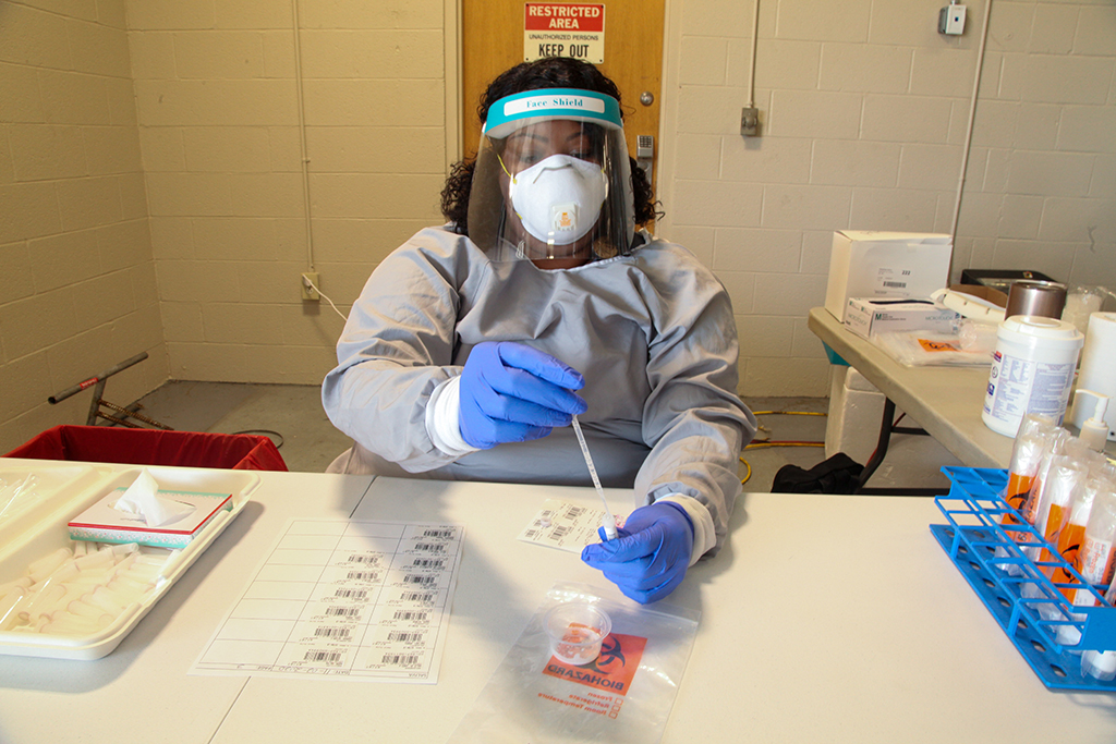 Woman in mask holding swab 