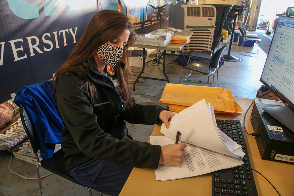 Woman in mask writing on papers