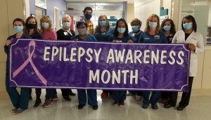 Members of Neurodiagnostics holding a banner