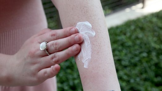Person applying sunscreen to arm