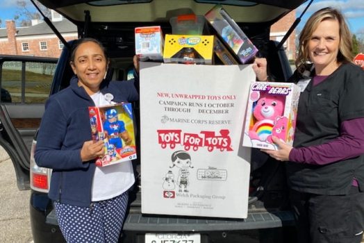 women next to car with toys in back