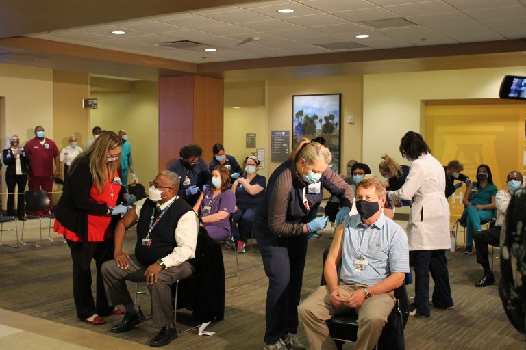 Nurses administering COVID-19 vaccines to patients.