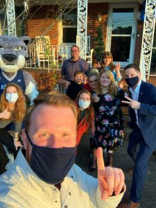 9 people pose for a selfie with the Augustus mascot