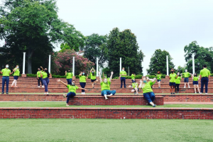 group of students in lime green polos pose in the Augusta University amphitheatre