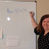 A woman writing on a dry erase board.