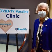 Woman posing near poster