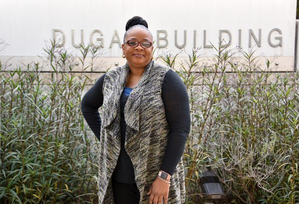 Woman in front of Dugas Building sign