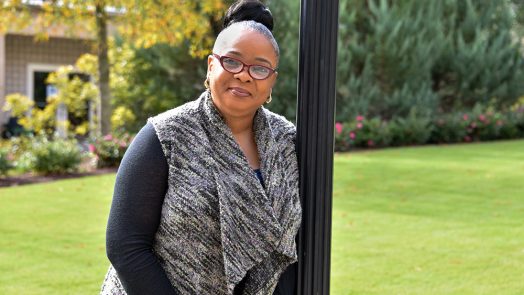 woman leans on lightpole