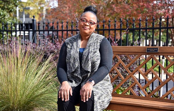 woman sits on wood bench