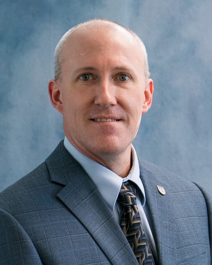 Man in suit and tie poses for a photo