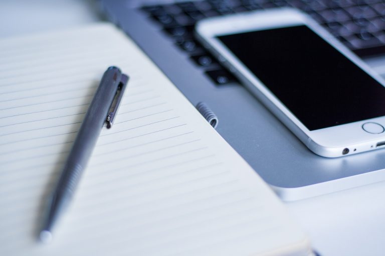 An image of a pen and smart phone on a desk.