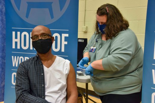 woman prepares to give shot to man