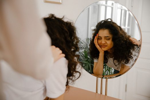 Young woman looking in mirror