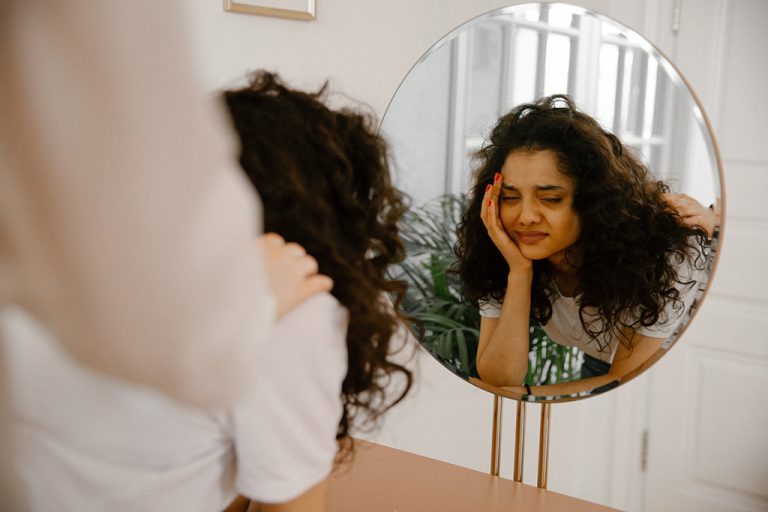 Young woman looking in mirror
